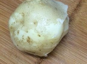 土豆放入电压力锅中压熟拿出，将皮趁热剥掉