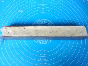 u形不粘饼干模具内铺上保鲜膜，把饼干面团用硅胶刀铲入模具内，表面整理平整。送入冰箱冷冻60分钟。