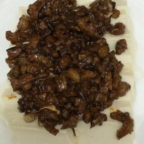 把炒好的酱料，放在豆腐上面