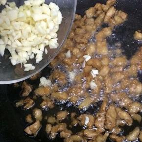 在把姜和蒜加入炒出蒜香味