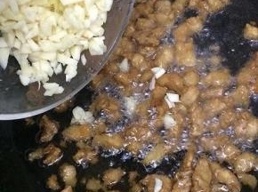 在把姜和蒜加入炒出蒜香味