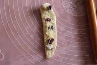 左边向右折叠，抹上夹馅，从上往下卷起，接口捏紧。