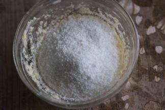 面团发酵时我们来制作椰蓉馅，黄油软化，加入细砂糖搅拌至糖融化，加入牛奶，搅匀，分三次加入全蛋液，每次完全搅匀再加下一次，最后加入椰蓉，用刮刀拌匀即可。