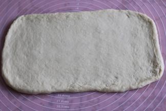 取出面团，擀成厚薄一致的长方形。