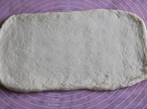 取出面团，擀成厚薄一致的长方形。