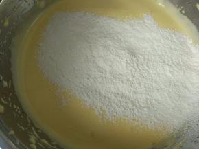 分两次加入过筛的低筋面粉（里面有盐和泡打粉），第一次加入用电动打蛋器数三个数，然后立刻停止，第二次加入低筋面粉，打五个数就好，然后用刮刀去翻拌，不能过度的用电动打蛋器打，防止面粉起筋。