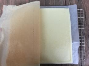 用一张干净的油纸盖在蛋糕表面，翻过来，揭开油布。