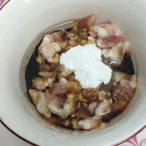 肉丁里加入少许的油、酱油和淀粉搅拌均匀，腌制五分钟