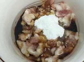 肉丁里加入少许的油、酱油和淀粉搅拌均匀，腌制五分钟