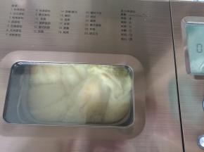 面团发酵到九分，刷蛋液，按“烘烤”键进行烘烤。