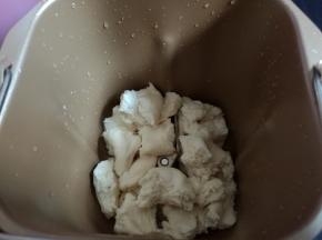 取出冷藏发酵好的面团，撕成小块，放入面包机桶内。