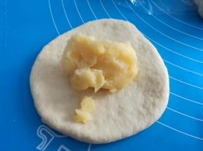 取一个小面团，擀面杖擀成圆片，放上适量自制的奶黄酱（自制奶黄馅的方法看我上一篇食谱），