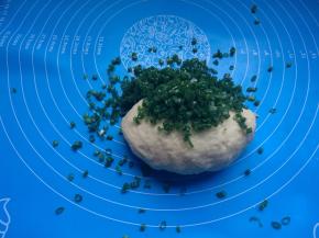 再用手揉成面团，放案板上揉匀。揉至面团光滑不粘手，加入洗净切好沥干水分的香葱。