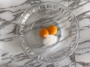 先来制作卡仕达酱。
蛋黄中加入细砂糖，用手动打蛋器搅打均匀。