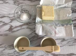 首先对模具进行防粘处理，这一步非常重要，处理好模具，舒芙蕾在烘烤的过程中才能垂直攀升。
黄油室温软化，用毛刷蘸取黄油刷满舒芙蕾碗内侧，刷好后倒入细砂糖，在碗内转一圈，让四周都粘满糖后，把碗在桌子上磕一下，倒出多余的糖。
多余的糖可以用于制作卡仕达酱，但不要用于打发蛋清。