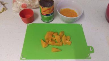 拿一罐蜜桃罐头，拿6片蜜桃出来搅烂，随便用什么东西搅烂就好，放碗中，再切6片蜜桃中块大小。