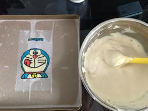 彩绘图案从冰箱里取出，将翻拌好的蛋糕糊倒入烤盘。