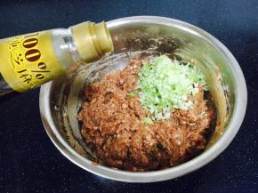 最后放入葱花，倒入少许香油，先用香油把葱花拌一下，然后再把葱花拌到肉馅里。
先用香油拌葱花是为了裹住葱花的汁水，免得葱花遇到盐后流汤汁，汤汁味太重。