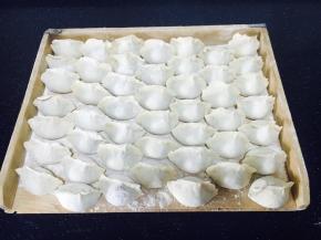 饺子屉上撒少许面粉，把逐个包好的饺子摆放好。
撒面粉是防止饺子粘在屉上。