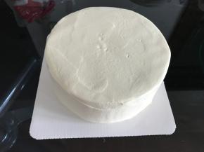 再倒200克淡奶油加20克糖至抹面状态，给蛋糕抹面，抹不好也没关系，反正淋面可以遮挡住
淡奶油的抹面状态就是可以刚刚好可以挂在打蛋头上不往下滴落的状态。新手可打的嫩一些，因为抹面的过程中抹刀和淡奶油反复接触也是在打发淡奶油，打嫩了可以补救，打过了就没法补救咯。