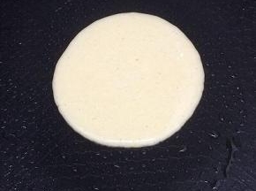 平㡳锅倒入少许的油，等温热后，用勺子舀一勺面糊倒入平底锅中，高一点倒比较圆