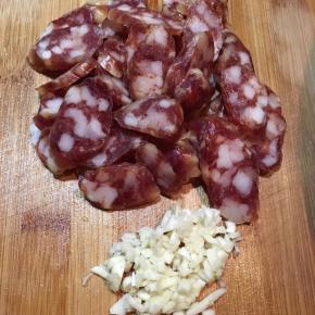 腊肠用开水烫洗一下，切薄片，蒜头切碎。