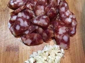 腊肠用开水烫洗一下，切薄片，蒜头切碎。