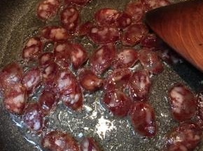 锅中加入少许油，大火烧热，下入腊肠翻炒。