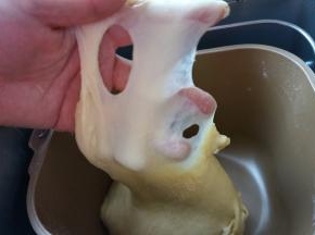 揉面结束，面团已经很光滑而且有弹性，面团慢慢扯出薄膜，手指一戳，洞口边缘呈圆滑状，揉面结束