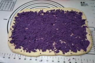 将提前蒸好并去皮的紫薯泥均匀地铺撒在面皮上，紫薯泥很干，一点儿水都没放，用手可轻松捻碎，用量多少可随意