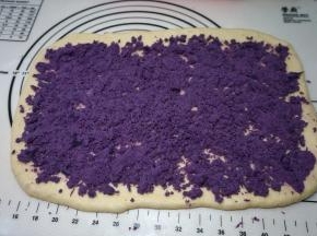 将提前蒸好并去皮的紫薯泥均匀地铺撒在面皮上，紫薯泥很干，一点儿水都没放，用手可轻松捻碎，用量多少可随意