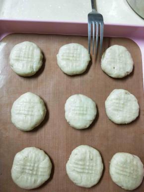 把面团分小块，揉成小圆球压扁，用叉子压出花纹