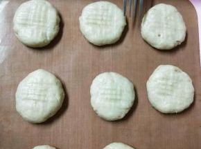 把面团分小块，揉成小圆球压扁，用叉子压出花纹