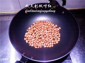 把晾干水分的花生倒入炒锅。