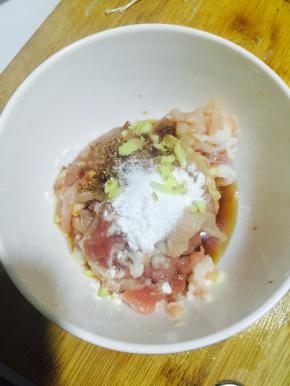 肉丝加入盐、料酒、糖、生粉、少许生姜碎、生抽、老抽，拌均匀