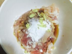 肉丝加入盐、料酒、糖、生粉、少许生姜碎、生抽、老抽，拌均匀