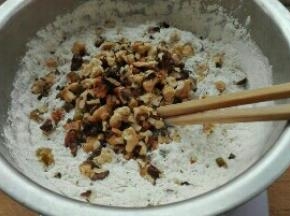 倒入混合均匀的蛋糊液中，同时放入葡萄干，核桃碎