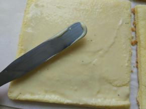 另外3/2的卡仕达酱取出，用抹刀抹一层卡仕达酱，从90℃角的地方卷起，新手建议把卡仕达酱熬的略高好卷，卷的时候手法轻柔，不然容易裂开。