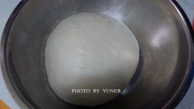 将揉好的面团收圆，放进容器内，盖上保鲜膜或湿布，进行第一次发酵。