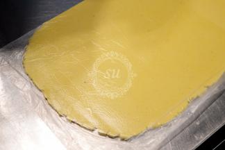 制作好柠檬内馅儿，我们的面团也松弛好啦。取出后用擀面杖擀平。操作尽量要快，不然很容易变软。如果变软无法操作就把擀好的挞皮送回冷藏稍微冷藏一会。