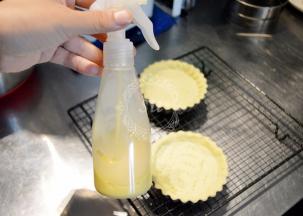 10分钟后取出挞模，喷上蛋黄液（蛋黄液是30g蛋黄+100g牛奶打散混合均匀后过筛，冰箱冷藏大概可以保存1周）。再送入烤箱，烘烤15分钟