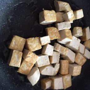 锅内倒入适量食用油，放入豆腐，煎至两面金黄。