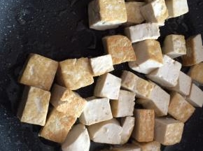 锅内倒入适量食用油，放入豆腐，煎至两面金黄。