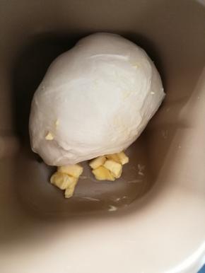 2面包机先用和面功能揉大约10分钟，然后转imix功能揉20分钟，这是面团能拉出厚得面膜，面团光滑。现在加入黄油继续揉。