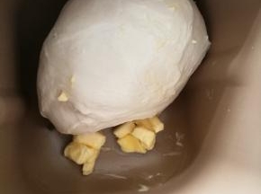 2面包机先用和面功能揉大约10分钟，然后转imix功能揉20分钟，这是面团能拉出厚得面膜，面团光滑。现在加入黄油继续揉。