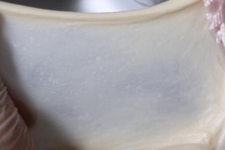 3再揉大约八分钟，切一小块面团，用手慢慢撑开，能拉出薄而坚韧的面膜。