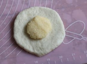 取一个面团，按扁擀开，包入椰蓉馅。