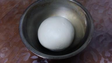 面团收圆，放盆中，盖上湿布或保鲜膜，进行一次发酵。