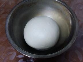 面团收圆，放盆中，盖上湿布或保鲜膜，进行一次发酵。