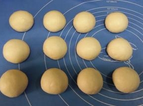 发酵好的面团，分割12等份。分别滚圆，盖保鲜膜松驰10~15分钟。